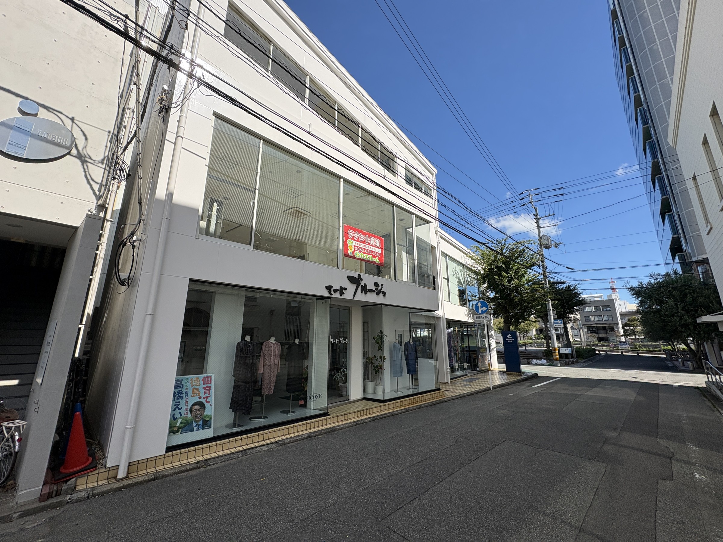 通りから見た、白い外壁と大きなガラス面の建物外観