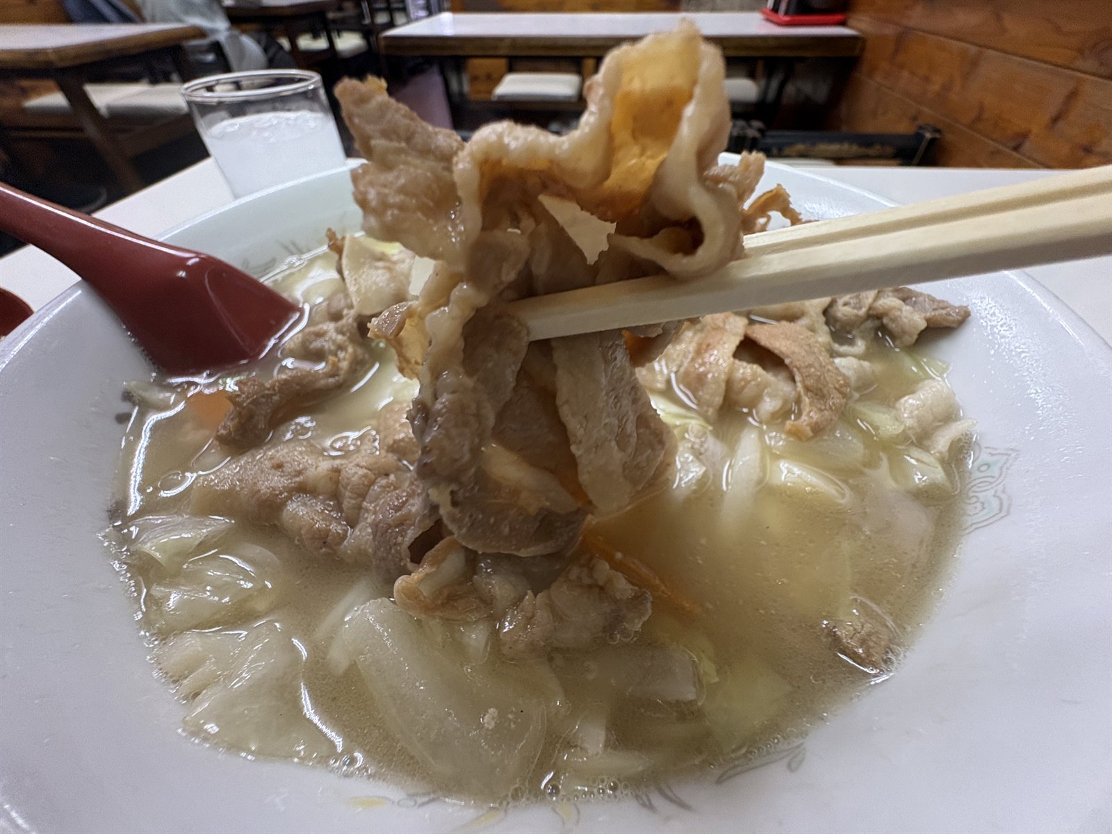 箸で持ち上げた五目そばの豚肉
